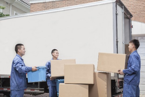 Packed household boxes and wrapped furniture ready for a Queens Park relocation